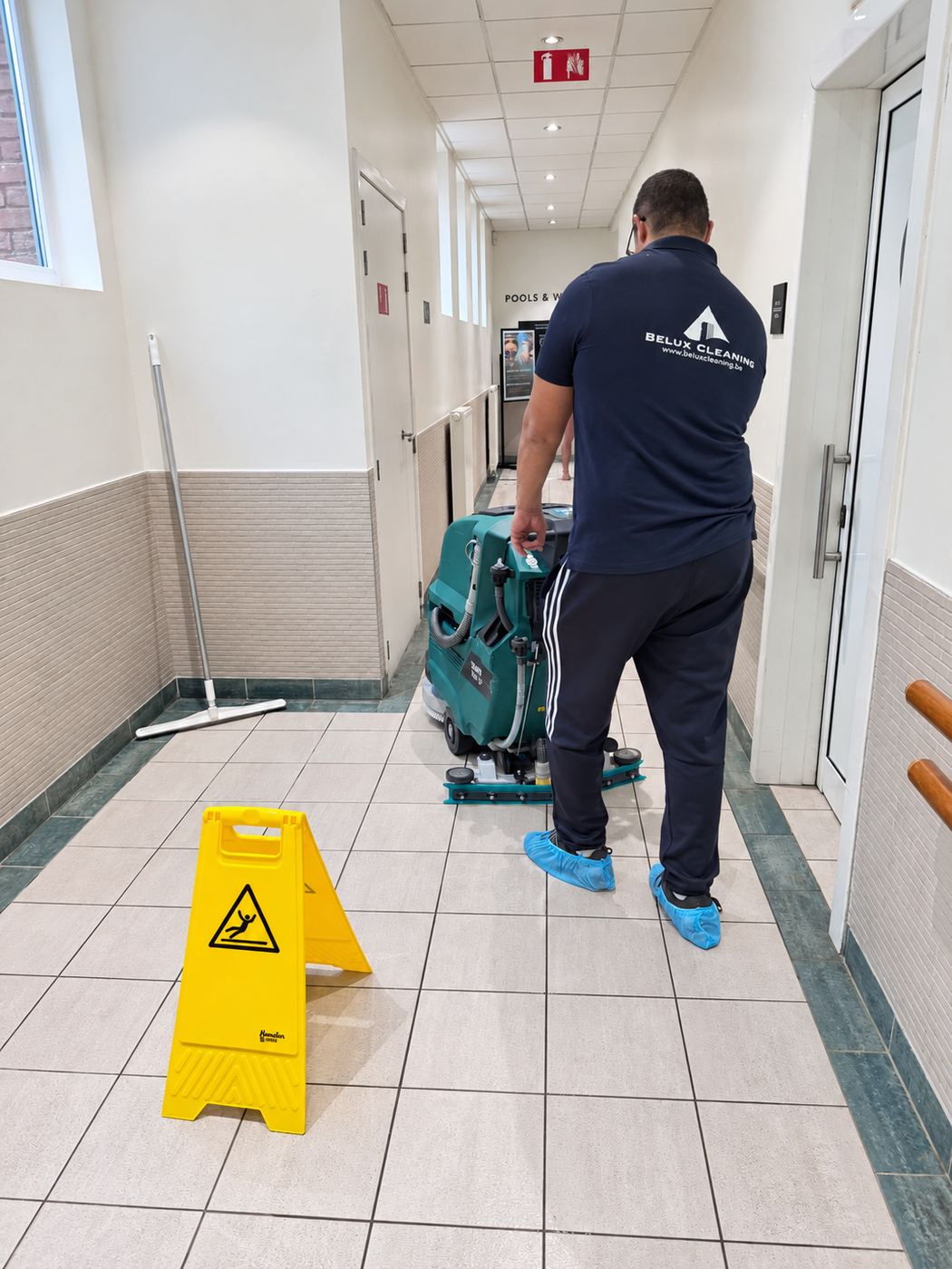 Cleaning a gym corridor with a scrubber-dryer